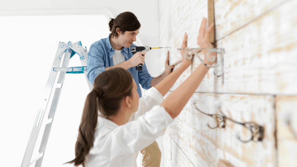 Couple attaching flat wood board on their wall