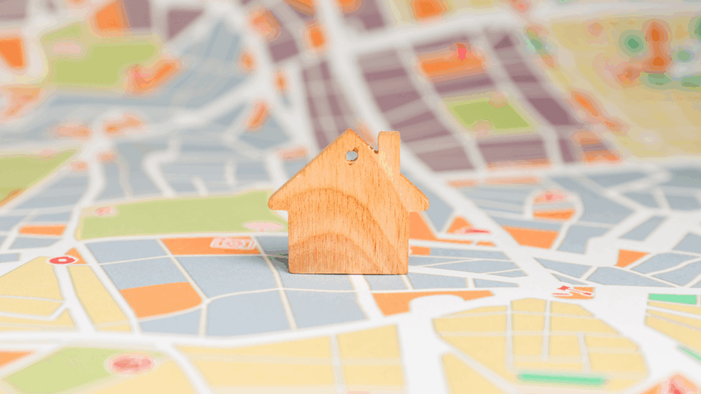 Miniature wooden home place on top of a map