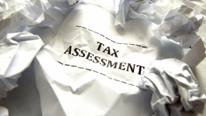 Tax assessment with crumpled papers around it