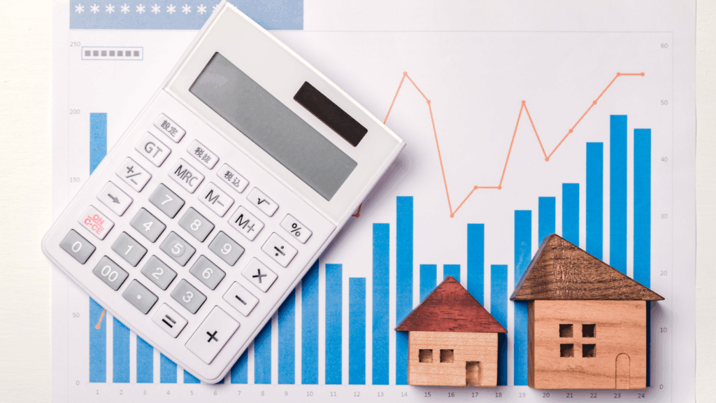Miniature houses, a graph, and a calculator used for property research