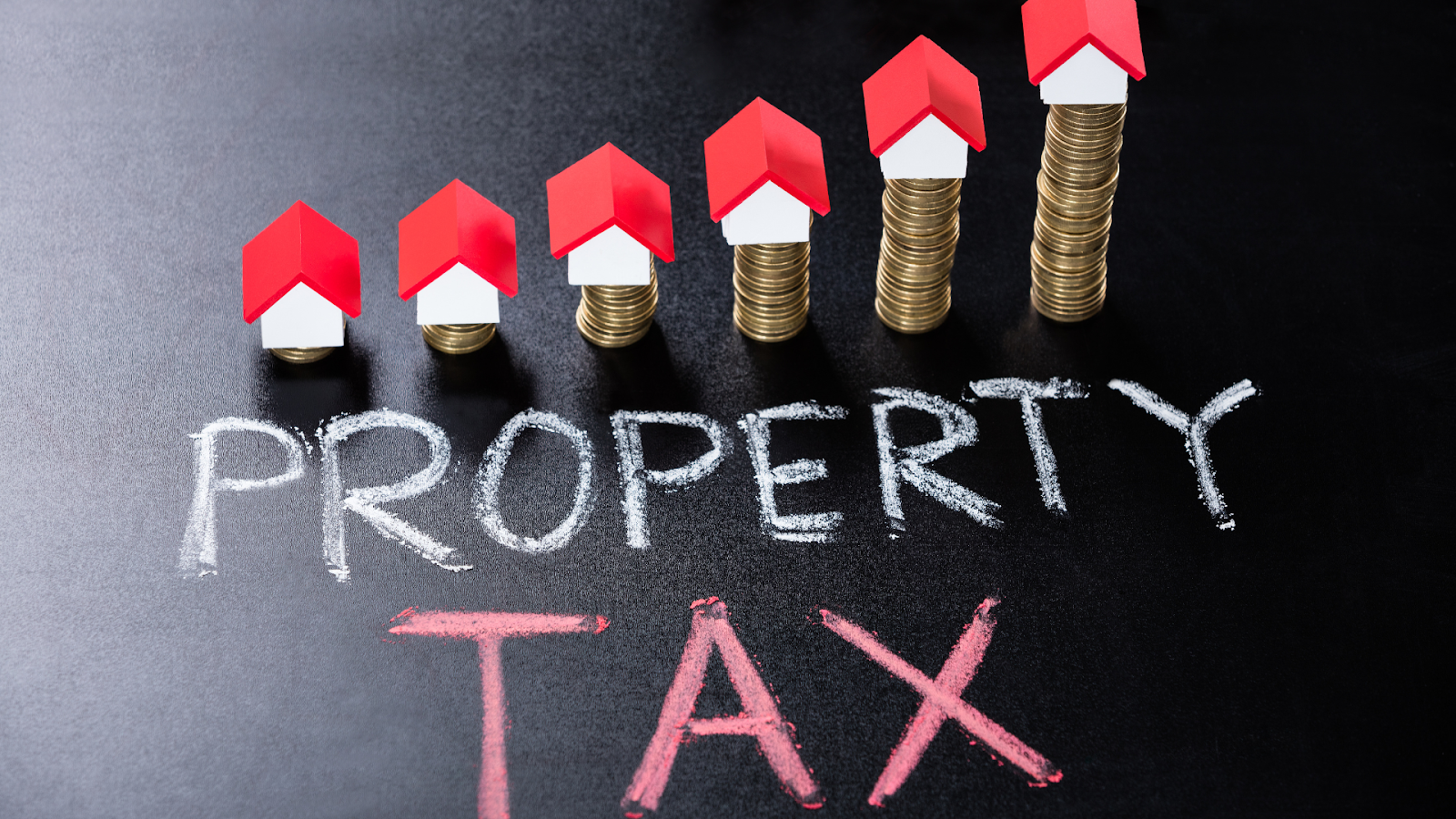 Property tax symbolized by coins and miniature houses