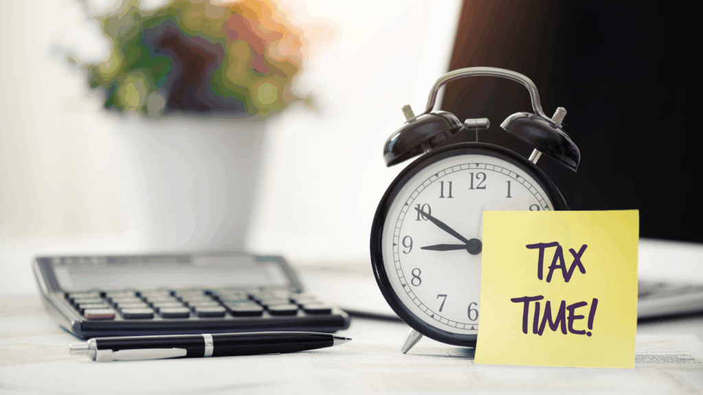 Calculator and alarm clock with note symbolizing tax deadline