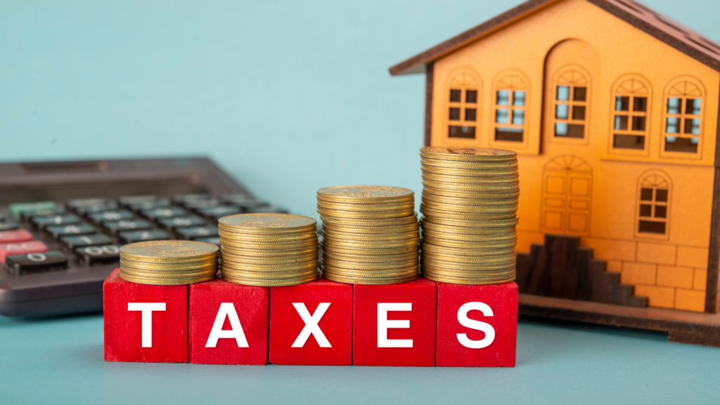 Property Tax Concept With Coins and House Model on Table