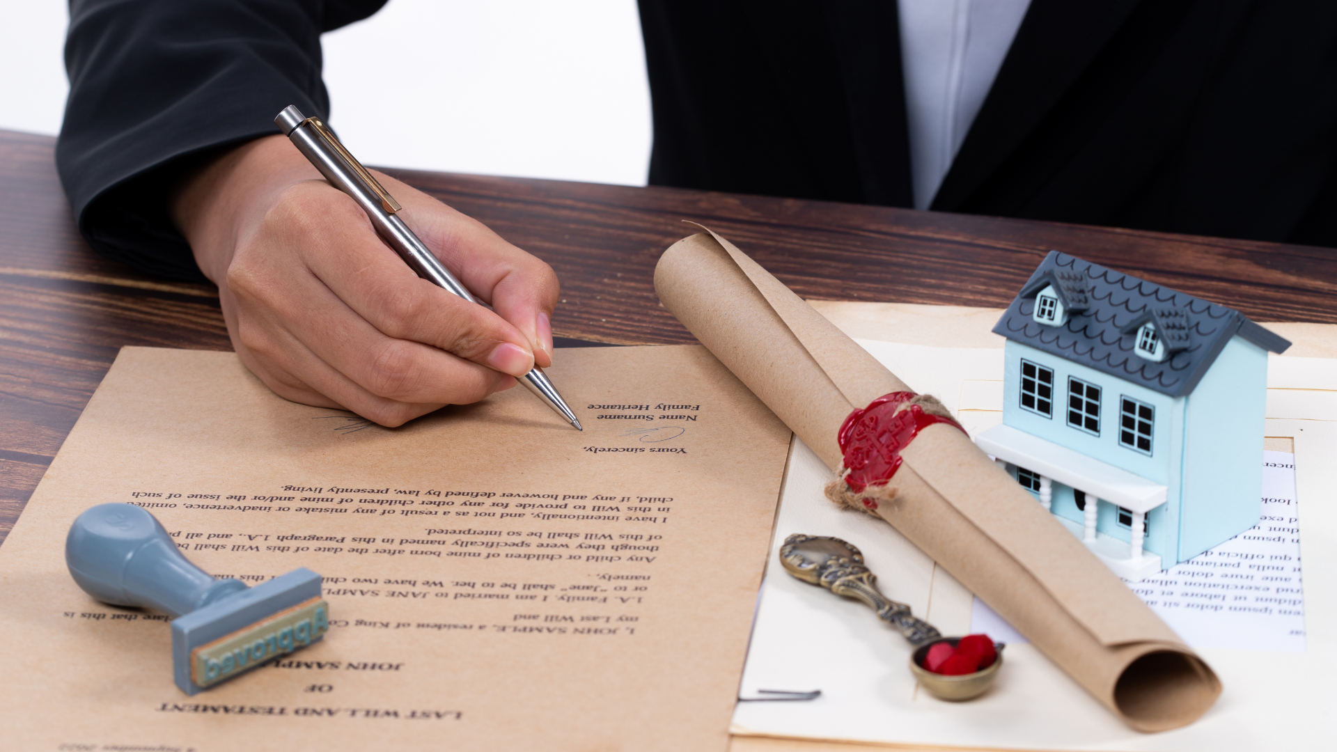 Signing inherited property documents with house model on the table
