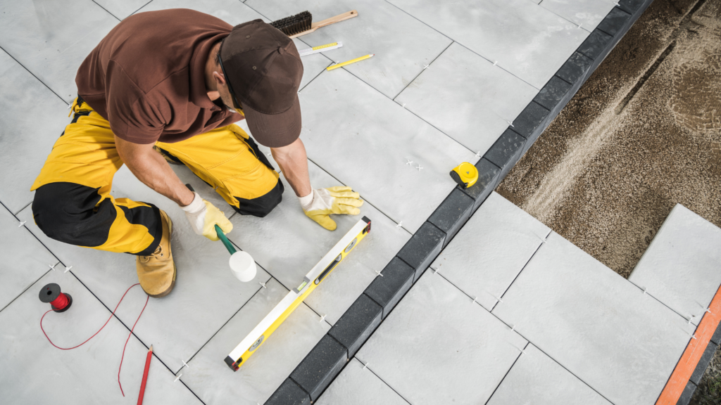 Worker laying patio tiles during basic home improvement project