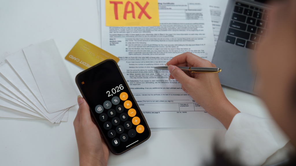 Homeowner calculating tax obligations alongside withholding paperwork