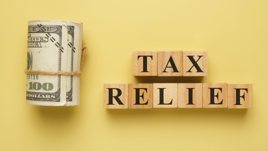 Tax relief savings concept with money and wooden letter blocks