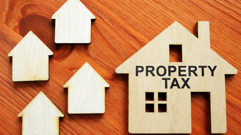 Wooden house cutouts with property tax label representing rising Texas assessments